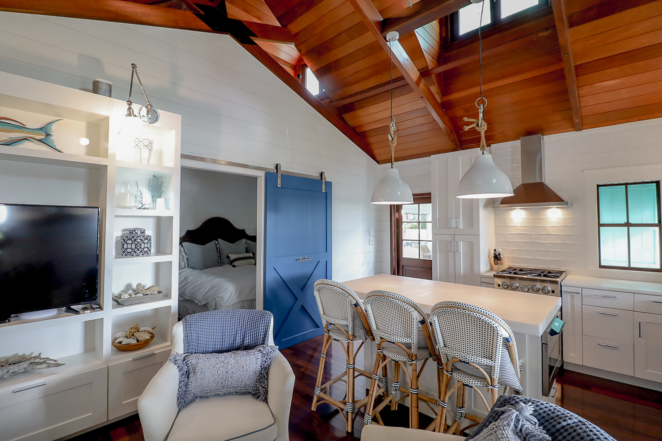 Kitchen with barn door to loft, vaulted cedar ceiling, and bar stools at island